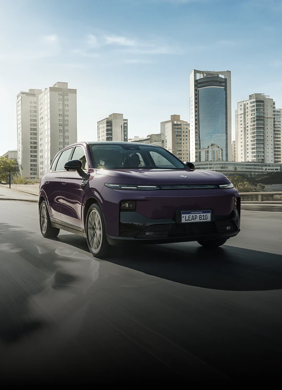 B10 Elétrico roxo em movimento por uma avenida urbana, com edifícios ao fundo. B10 Elétrico roxo em movimento por uma avenida urbana, com edifícios ao fundo.