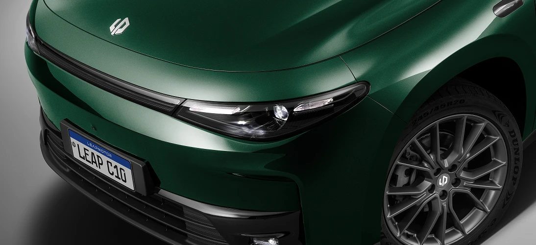 Detalhe da dianteira de um Leapmotor verde escuro, com farol fino em LED integrado ao capô e roda dianteira em destaque.